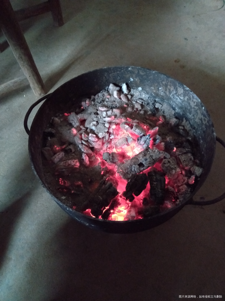 今天她爸爸没上班,一边烤火一边烤红薯。